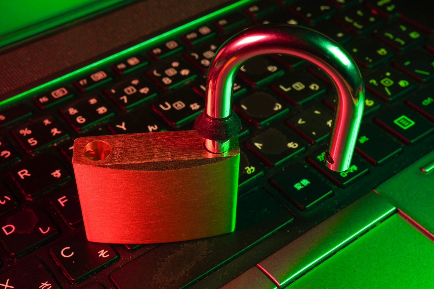Un lucchetto d'argento aperto si trova sulla tastiera di un laptop.